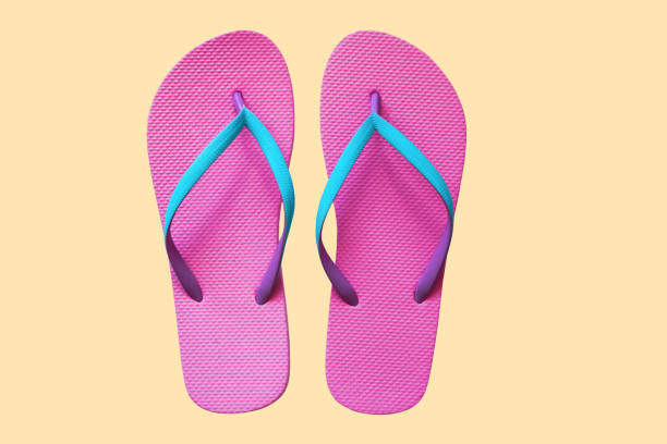 istock Pink flip flops isolated on yellow background. Top view 1021850496