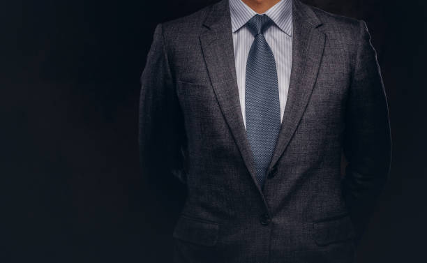 ritratto ritagliato di un uomo d'affari di successo vestito con un elegante abito formale. - suit necktie close up gray foto e immagini stock