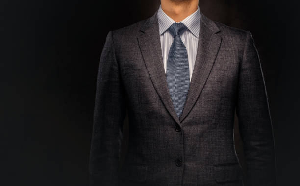 ritratto ritagliato di un uomo d'affari di successo vestito con un elegante abito formale. - suit necktie close up gray foto e immagini stock