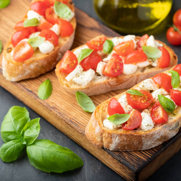 istock Bruschetta with tomatoes, mozzarella cheese and basil on a cutting board. Traditional italian appetizer or snack, antipasto 1021868156
