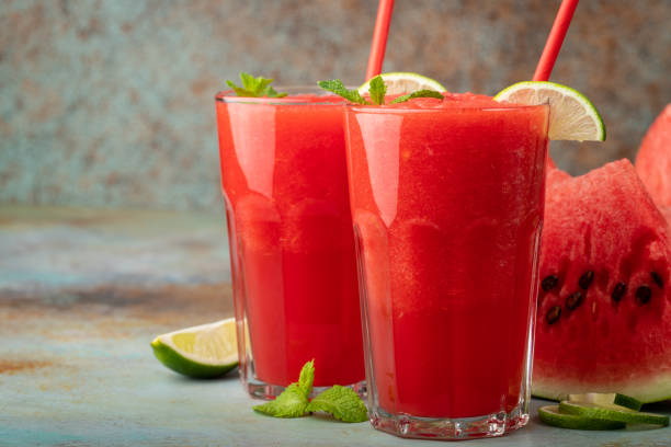 istock Watermelon slushie with lime, summer refreshing drink in tall glasses on a blue rusty background. with copy space 1021868174
