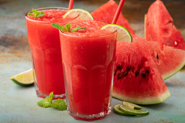 istock Watermelon slushie with lime, summer refreshing drink in tall glasses on a blue rusty background 1021868182