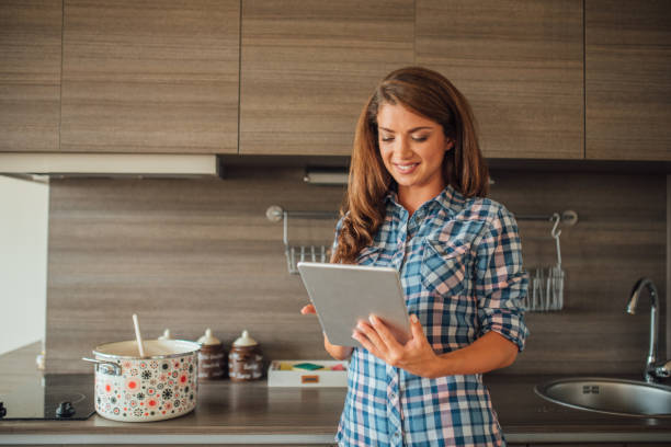 istock Smiling young woman looking at digital tablet in her hands 1021874506