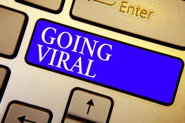 Photo of Text sign showing Going Viral. Conceptual photo image video or link that spreads rapidly through population Keyboard blue key Intention create computer computing reflection document.