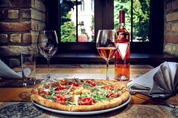 Pizza and red wine on the table. Restaurant ambiente.