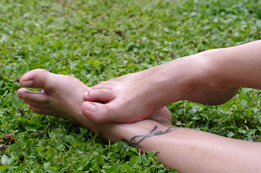 Wet female feet on grass with natural nails