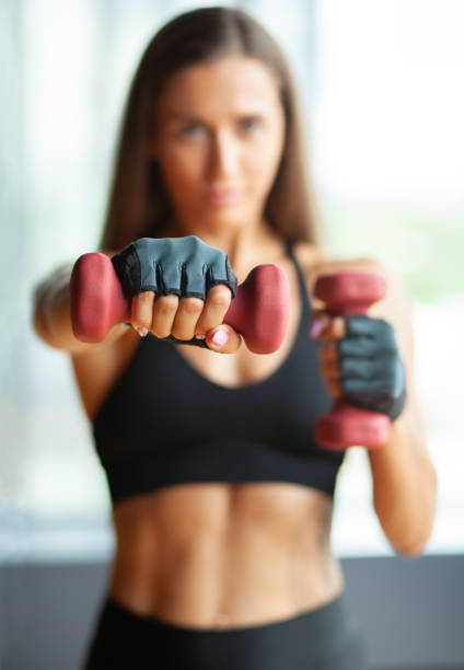 istock hands with dummbells, defocused sportswoman 1021924672