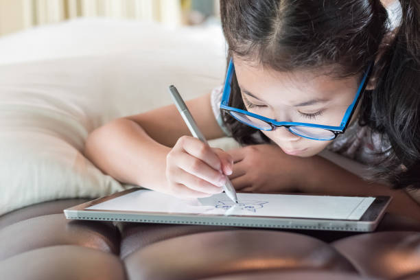 istock Asian school child girl using smart  tablet device digital technology drawing on innovative touchscreen surface 1021950236