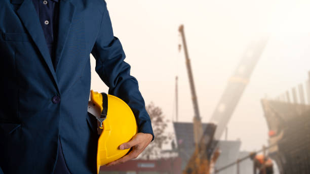 istock Engineer or worker hold yellow helmet for workers security with theodolite transit equipment at construction site outdoors work. 1021950318