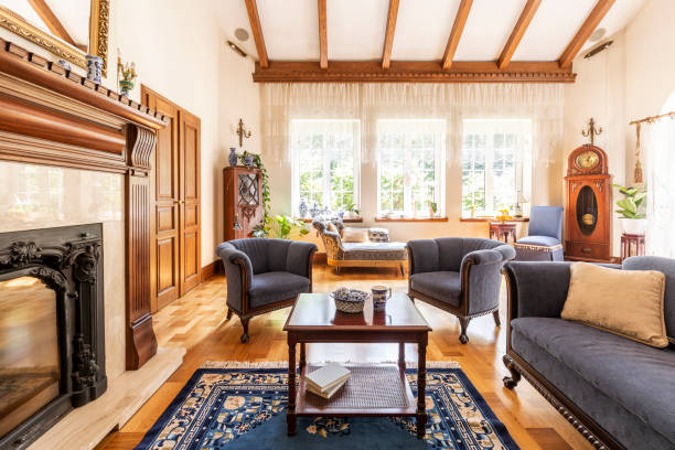 istock Dark wooden table on carpet between blue armchairs and sofa in luxury interior with fireplace. Real photo 1021952530