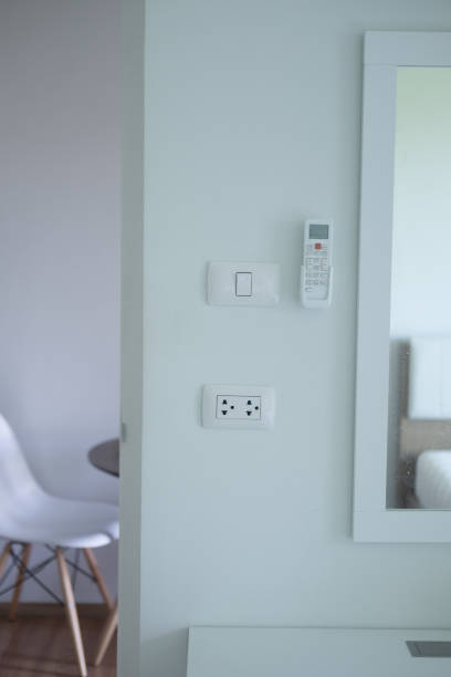 istock Air conditioner remote control, outlet and electrical switch on wall 1021998374