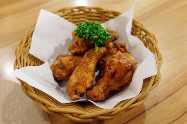 istock Fried chicken wings in white plate on wooden table. 1022053346