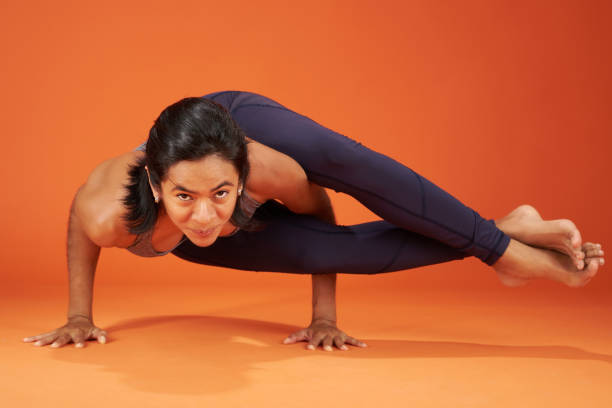 Eight-Angle yoga Pose woman show on orange color studio background