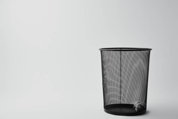 office trash bin with crumpled paper on white