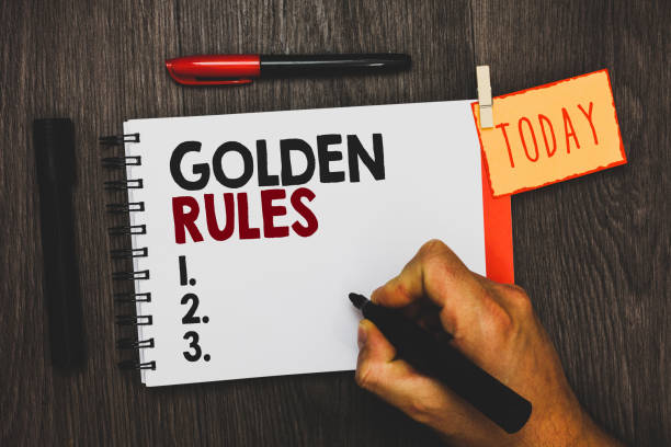 istock Text sign showing Golden Rules. Conceptual photo Basic principle that should be followed Important Principle Man holding marker notebook clothespin hold reminder cup markers wood table 1022078328