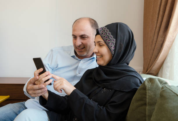 istock Muslim couple using mobile phone at home 1022080856