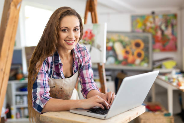 Young woman using laptop in art studio