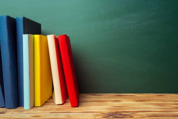 istock Classroom with blackboard, wooden table and books 1022097132