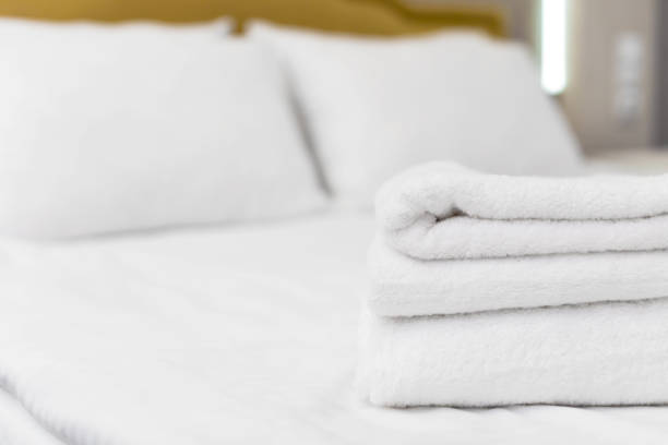 Clean towels on hotel bed.