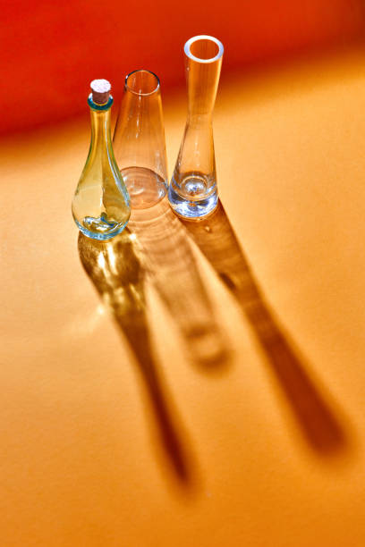 istock Empty glass vases with long shadows on a doutone red yellow paper background. 1022101740