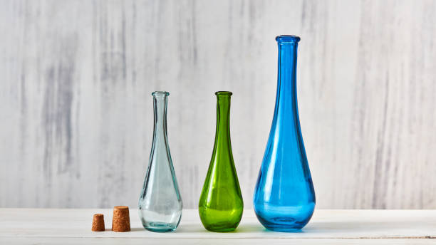 istock Three colorful glass bottles different sizes for saving natural olive oil on a gray background, a table 1022103102