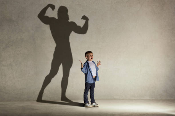 istock The little boy dreaming about athletic bodybuilder figure with muscles 1022105600