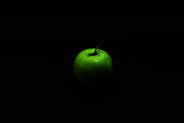 istock Green apple with drops of water on a black background 1022106396