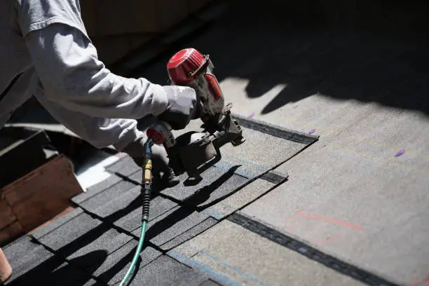 Photo of Installing new roof with nail gun