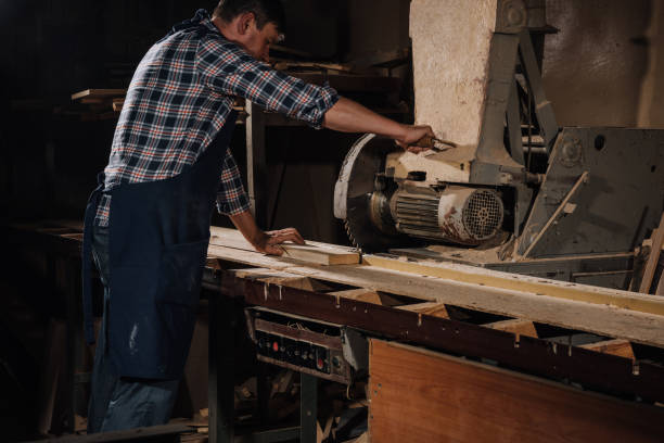 istock side view of carpenter using saw at wooden workshop 1022110054