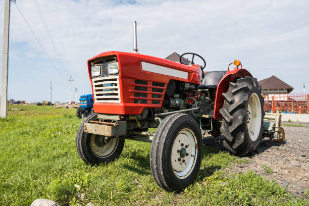 istock A small mini red tractor stands on a farm yard on green grass and waits for work to begin. 1022113142