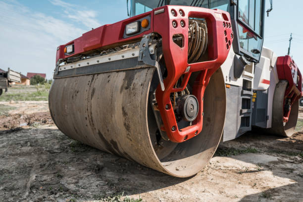 Red Heavy Vibration roller at asphalt pavement works. Road repairing. Road construction and repairing asphalt pavement works with a blue sky. stock photo