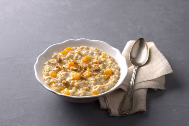 istock Pumpkin oatmeal with honey and nuts on a gray background 1022122054