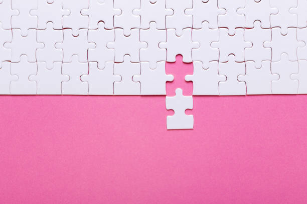 istock White puzzle on pink background. Top view 1022127126