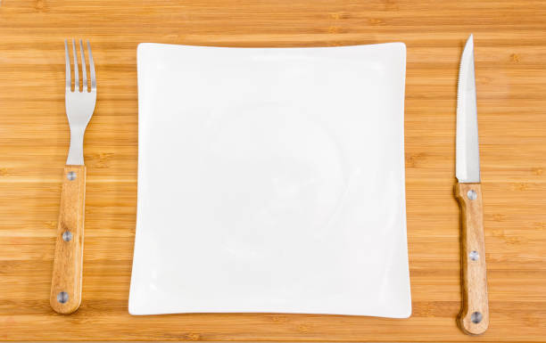 istock Empty square white dish, fork and knife with wooden handles 1022127390