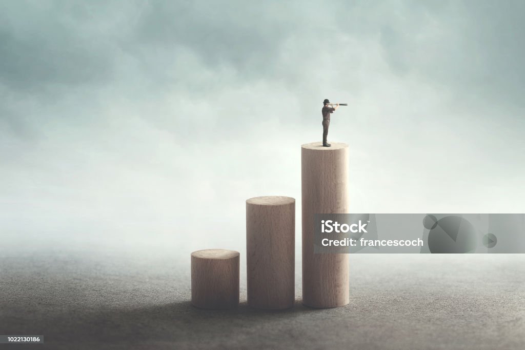 man on the top with binoculars observing the future ambitious man climbs to the top to see far The Way Forward Stock Photo