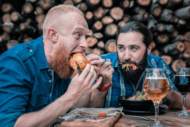 istock Hungry red-haired man biting large piece of his burger 1022134704