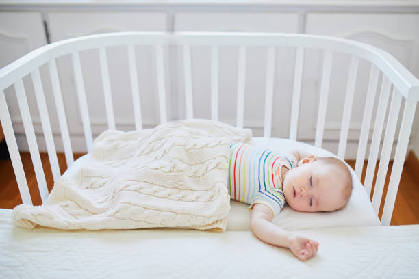 istock Baby girl sleeping in co-sleeper crib 1022137148