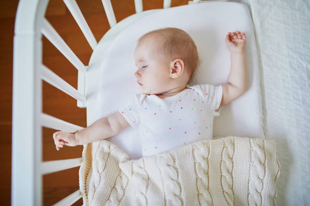 istock Baby girl sleeping in co-sleeper crib 1022137204