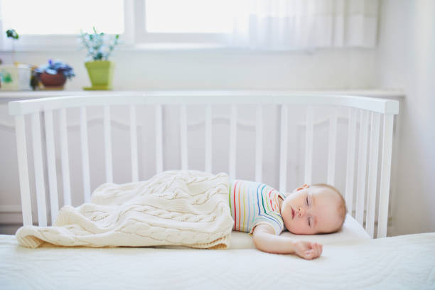 istock Baby girl sleeping in co-sleeper crib 1022137246