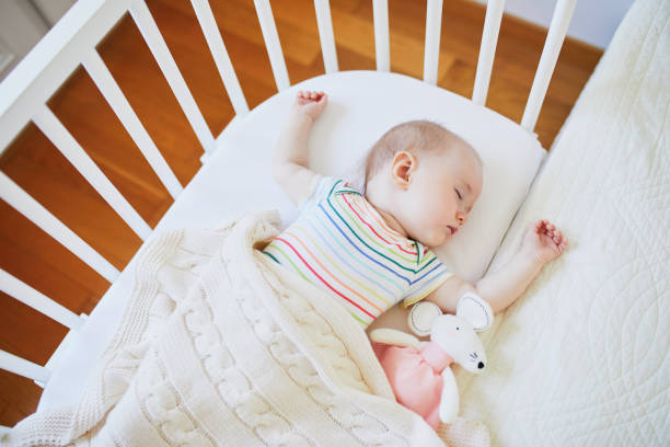 istock Baby girl sleeping in co-sleeper crib 1022137306