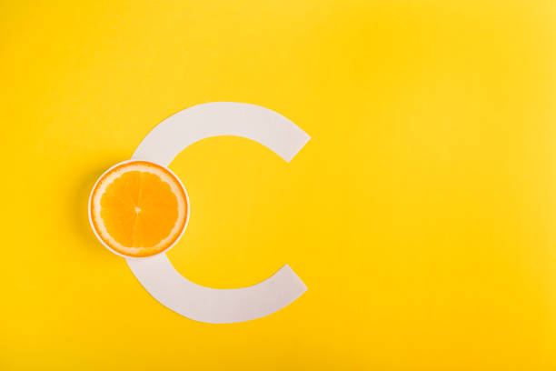 Orange and letter C on a yellow background. The concept of Vitamin S. Autumn protection against colds, antioxidant Orange and letter C on a yellow background. The concept of Vitamin S. Autumn protection against colds and colds, antioxidant. vitamin c stock pictures, royalty-free photos & images