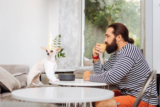 istock Dark-haired man wearing red shorts drinking tasty latte 1022142304