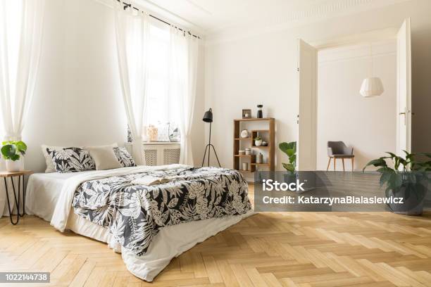 Stylish Apartment Interior With White Walls And Herringbone Wooden Floor A View From A Bedroom With A Big Bed To Another Room With An Armchair Real Photo Stock Photo - Download Image Now