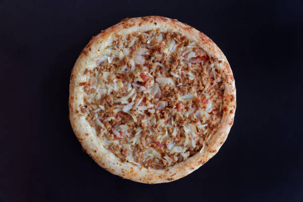 Backed tuna pizza on black background