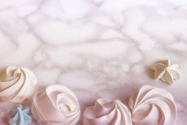 Flat lay pale pink meringue dessert on marble background with copy space in pretty pastels colors Pale pink sweet meringue dessert on the marble background with a copy space flat lay close-up for wedding card in pretty pastels colors wedding cake close up macro stock pictures, royalty-free photos & images