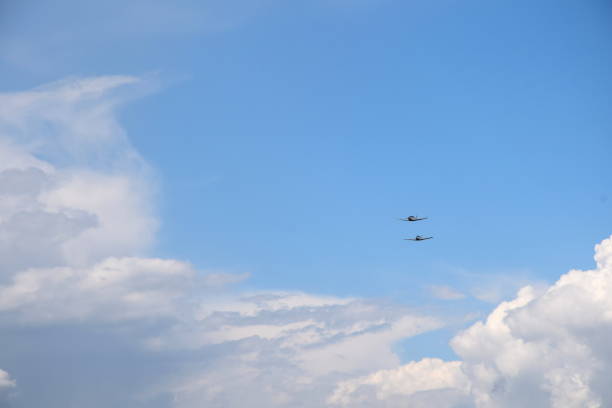 istock Two ultra light planeswith their rotors on flying through the sky below cloudy summer sky and very close to one another seen during one of trips in Poland 1022154056