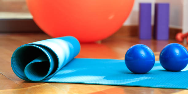 istock Yoga mat and exercise weights on wooden floor 1022159808