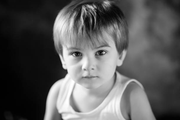 Portrait of the little boy.  Quiet  boy 3-4 years looking at the camera. Emotional portrait close up. Black-and-white image stock photo