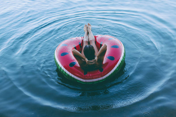 летнее время релаксации - inner tube swimming lake water стоковые фото и изображения