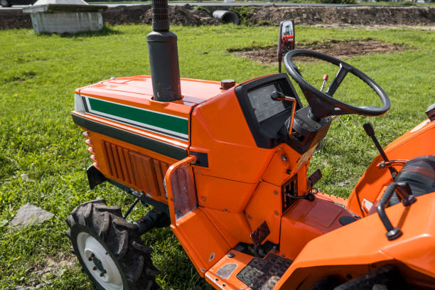istock A small mini orange tractor stands on a farm yard on green grass and waits for work to begin. 1022173514